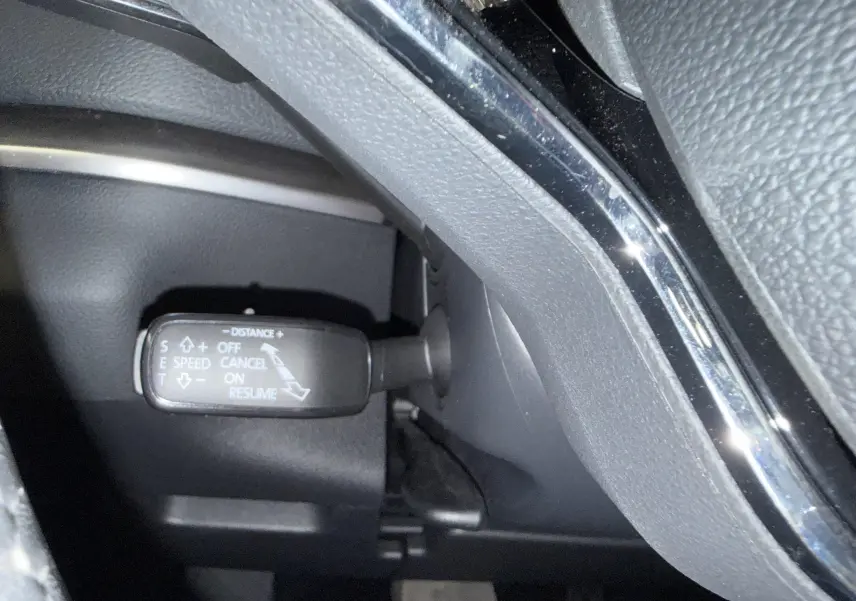 Gros plan sur la commande de régulateur de vitesse du Skoda Karoq 2023, intérieur noir avec détails chromés.