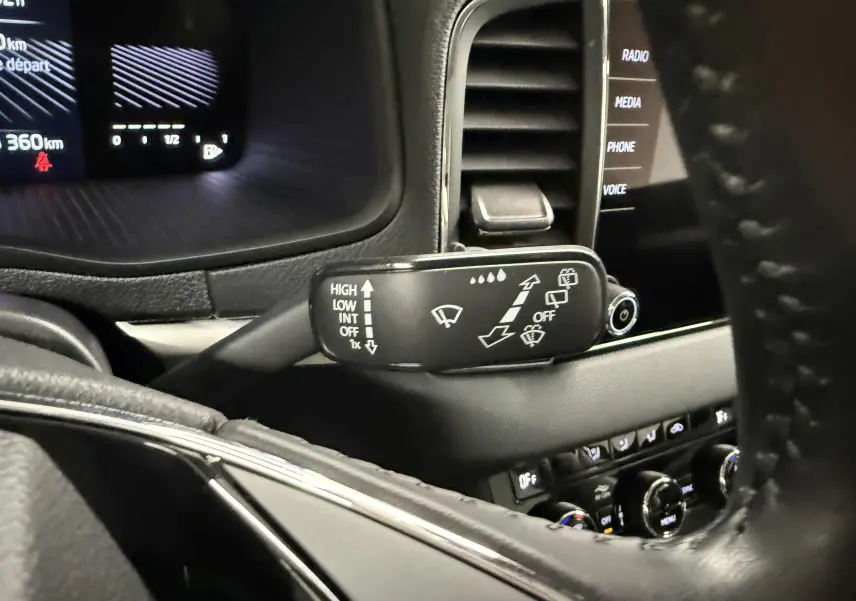 Gros plan sur la commande d’essuie-glace côté gauche du tableau de bord du Skoda Karoq 2023 intérieur noir.
