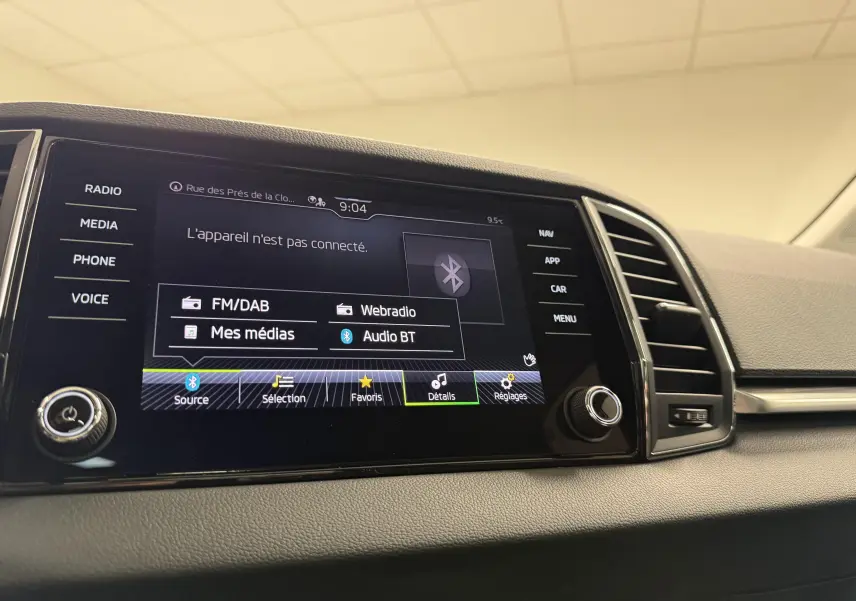 Écran tactile central de la Skoda Karoq 2023 affichant les options multimédias, avec tableau de bord gris et aérateurs.