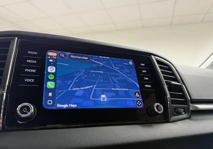 Écran tactile central du Skoda Karoq 2023 affichant la navigation Google Maps dans l'habitacle noir.