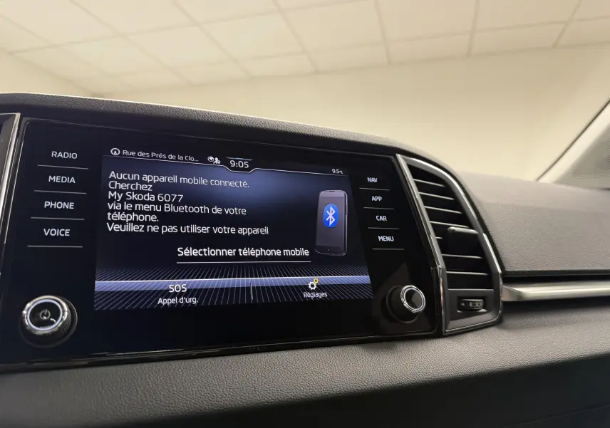 Écran tactile central du Skoda Karoq 2023 affichant le menu Bluetooth, avec commandes autour et aérateurs à droite.