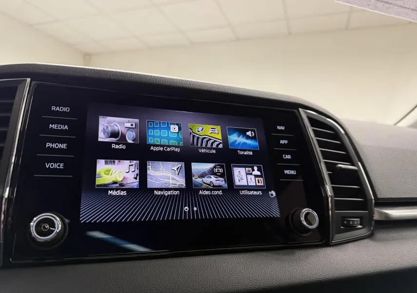 Écran tactile central du Skoda Karoq 2023 affichant les options multimédia et navigation, vue intérieure rapprochée.