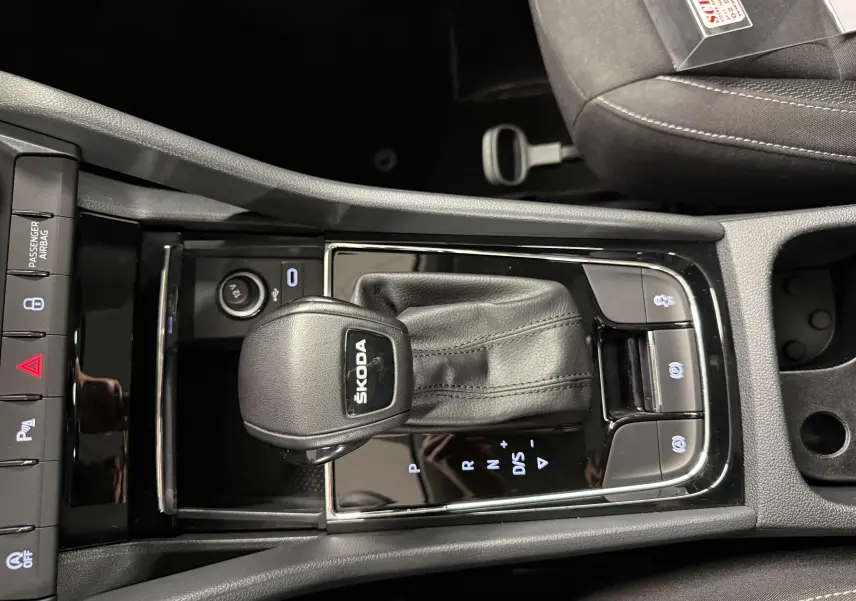 Vue rapprochée de la console centrale du Skoda Karoq 2023 avec levier de vitesses automatique et boutons de contrôle.