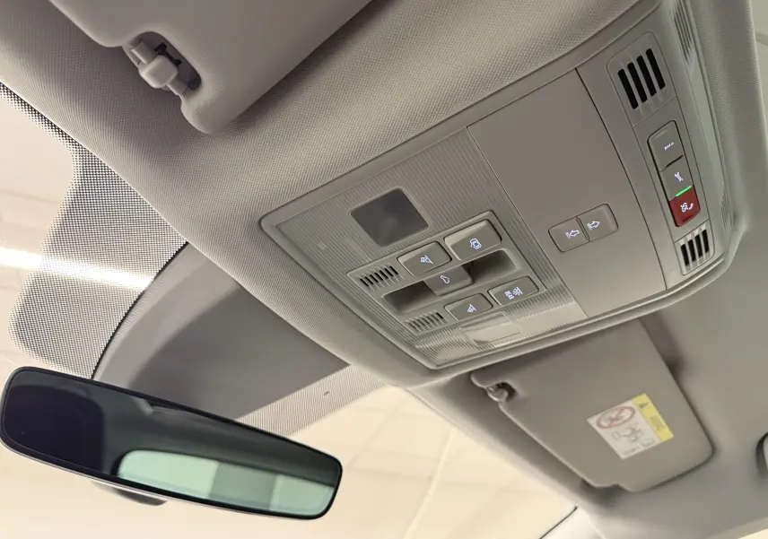 Vue intérieure du plafond avant du Skoda Karoq 2023 avec commandes de toit ouvrant et rétroviseur intérieur.