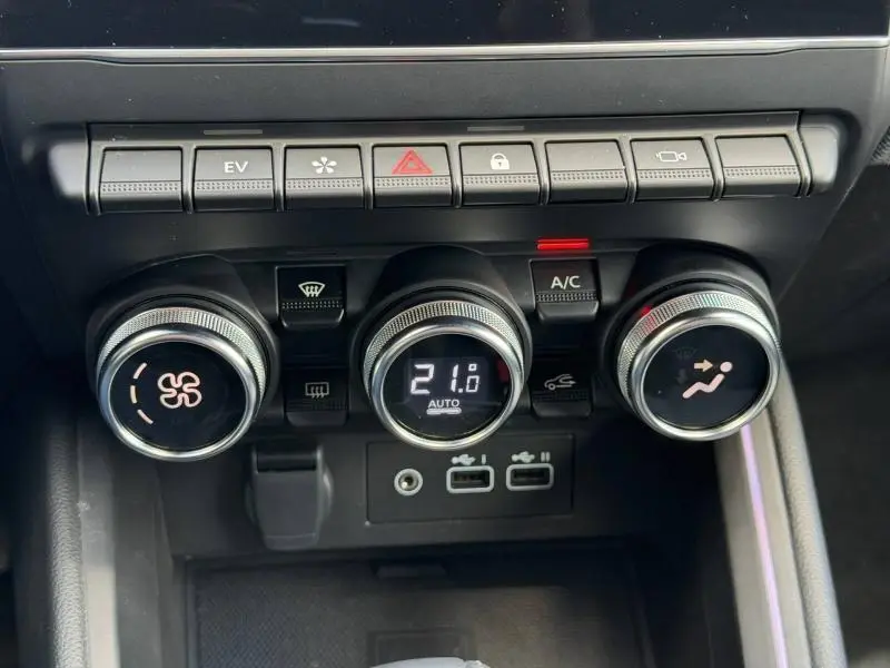 Gros plan sur la console centrale de la Renault Clio 1.6 E-Tech 145ch hybride, avec commandes climatisation et boutons fonctionnels.
