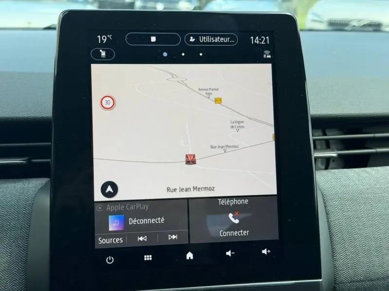 Écran tactile central de la Renault Clio 1.6 E-Tech rouge Flamme, affichant la navigation GPS et les options connectées.