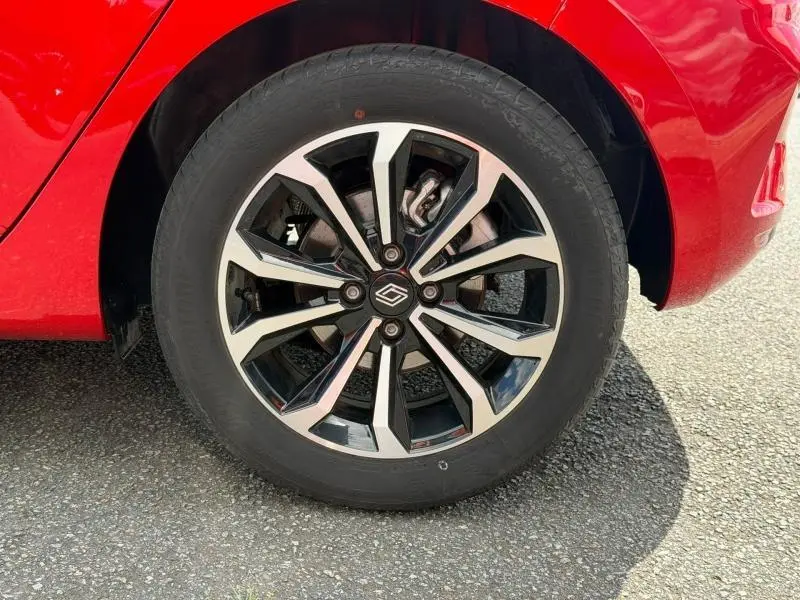 Gros plan sur la roue avant droite de la Renault Clio 1.6 E-Tech 145ch rouge Flamme avec jante alliage moderne.