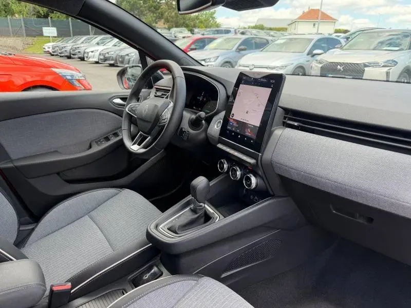 Vue intérieure côté conducteur de la Renault Clio 1.6 E-Tech 145ch hybride avec écran tactile vertical et sellerie grise.
