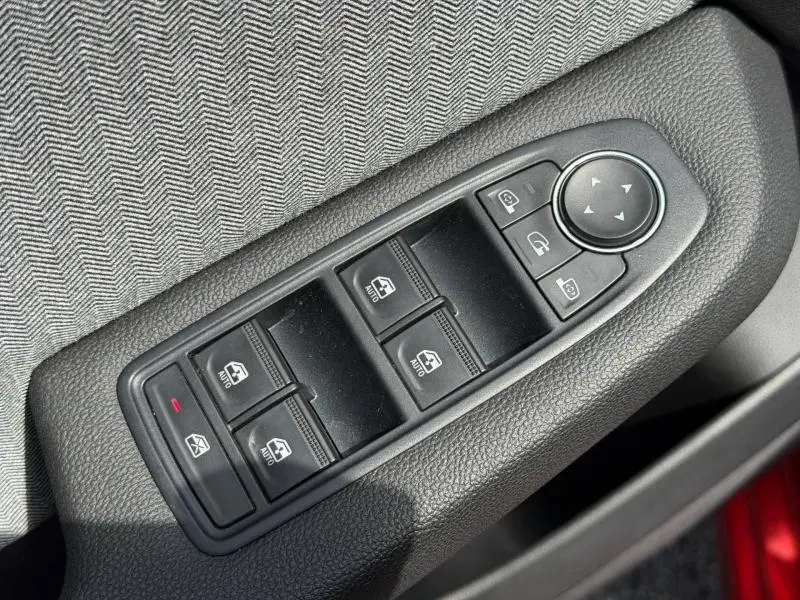 Gros plan sur les commandes des vitres électriques et rétroviseurs côté conducteur de la Renault Clio 1.6 E-Tech Rouge Flamme 2025.