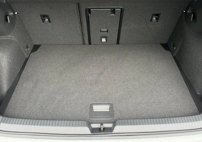 Vue plongeante sur le coffre spacieux et tapissé de gris d'une Volkswagen Golf 1.5 eTSI EVO2 blanc Oryx nacré.