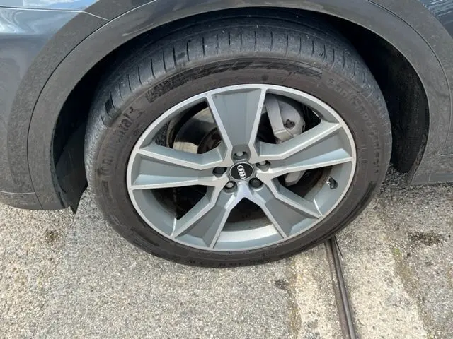 Gros plan sur la roue avant droite gris foncé de l'Audi Q5 2018 avec jante en alliage à cinq branches doubles.