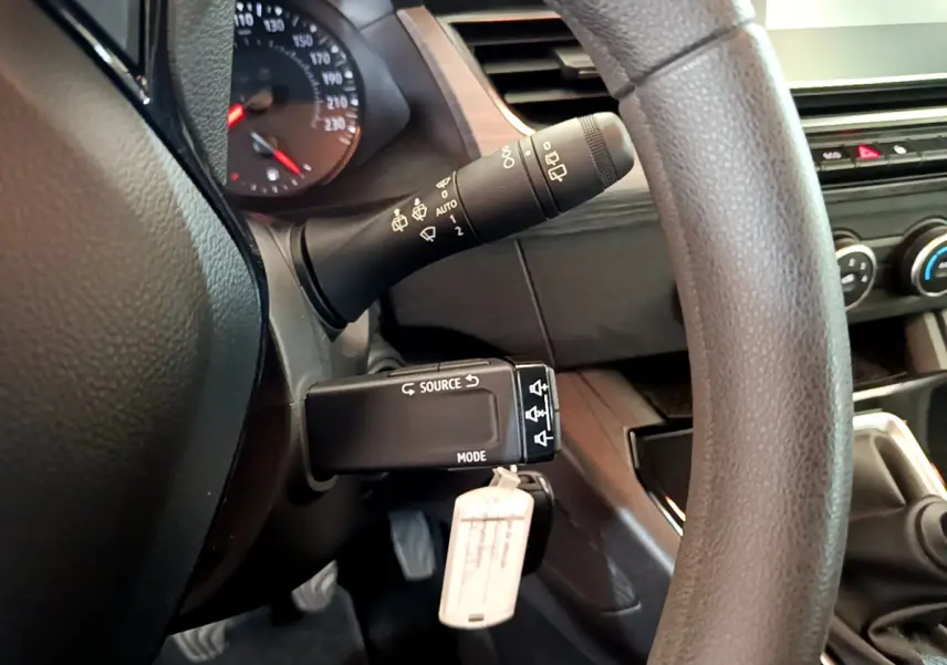 Gros plan sur la commande multifonction et partie du volant du Renault Kangoo bleu 2023, intérieur noir.