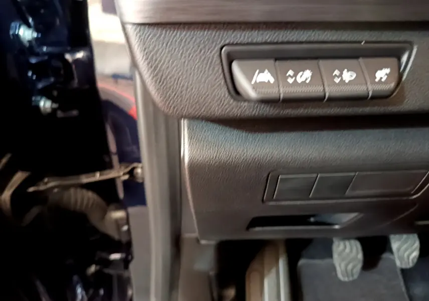 Vue intérieure côté conducteur du Renault Kangoo bleu 2023, montrant les commandes d'assistance et les pédales.