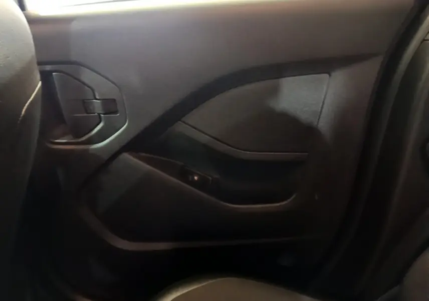 Gros plan sur la porte arrière droite intérieure noire du Renault Kangoo Equilibre 2023, avec poignée intégrée et accoudoir.