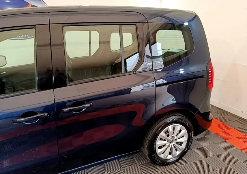 Profil arrière droit du Renault Kangoo bleu 2023 avec porte coulissante et feux arrière LED visibles.