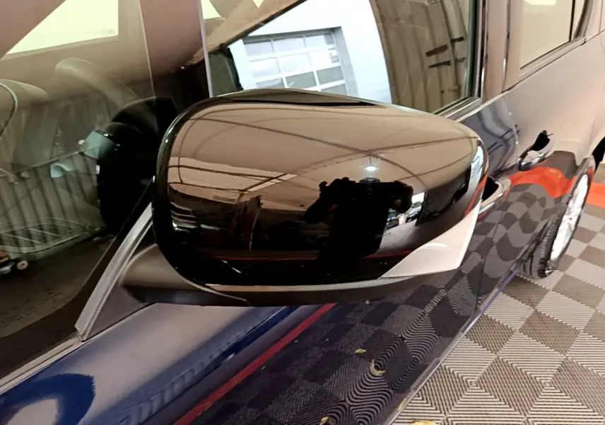 Rétroviseur droit noir brillant du Renault Kangoo bleu 2023, vue rapprochée côté passager avec reflet intérieur visible