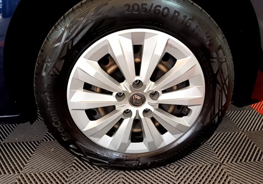 Gros plan sur la roue avant droite du Renault Kangoo bleu 2023 avec jante argentée et logo central Renault.