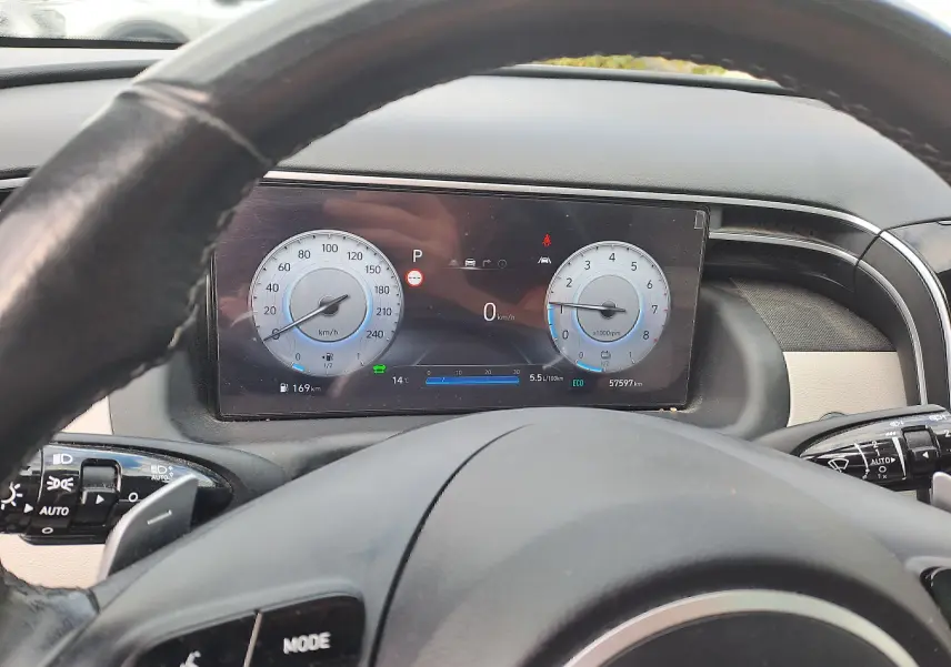 Vue depuis le siège conducteur du tableau de bord numérique du Hyundai Tucson 2023, affichant vitesse et compte-tours.