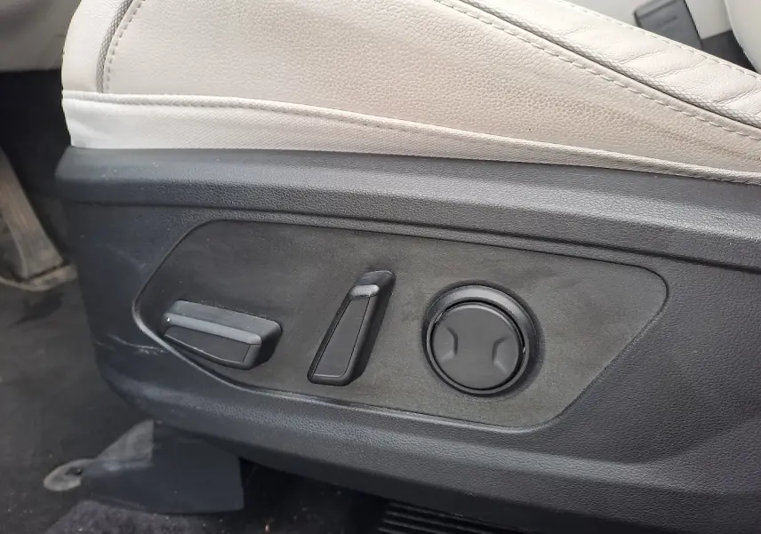 Détail des commandes électriques du siège beige côté conducteur dans un Hyundai Tucson 2023 hybride.
