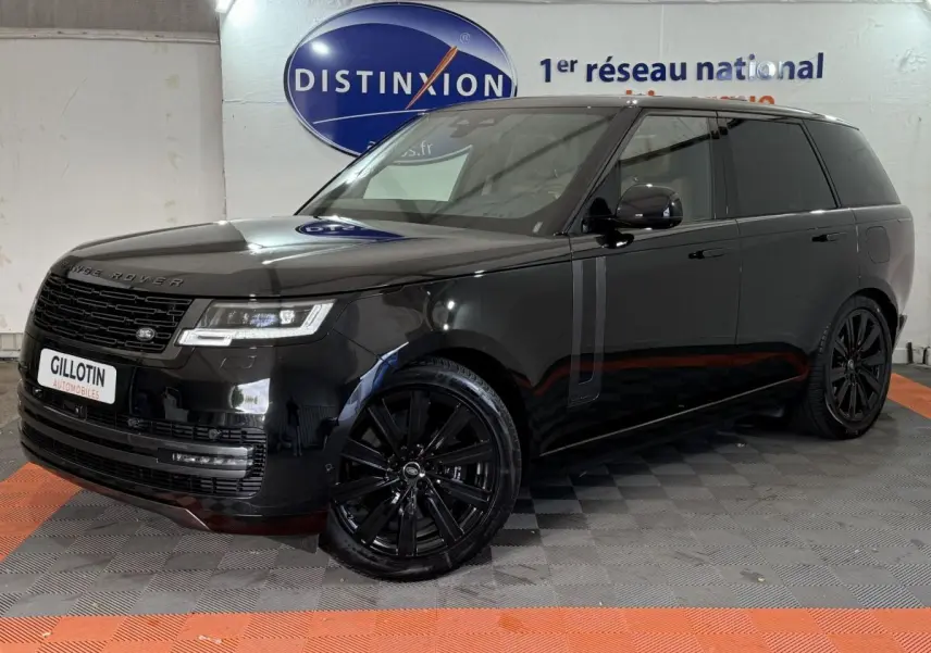 Range Rover PHEV P550e noir, vue 3/4 avant droit, jantes noires et vitres teintées dans un showroom.