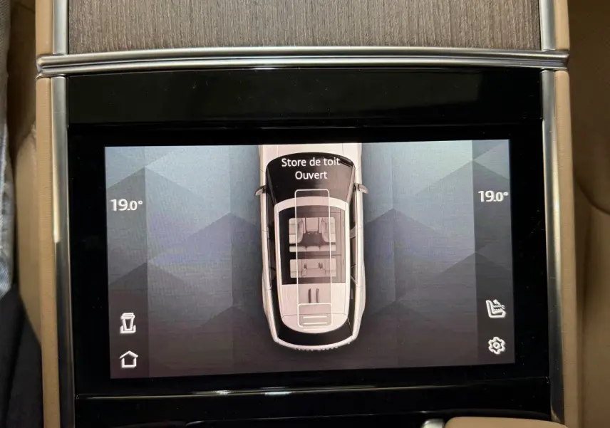 Écran tactile central montrant vue aérienne du Range Rover noir avec toit ouvrant ouvert, température 19°C.