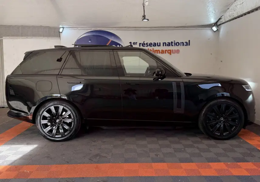 Vue de profil côté gauche d'un Range Rover PHEV P550e Autobiography noir brillant avec jantes noires en intérieur.