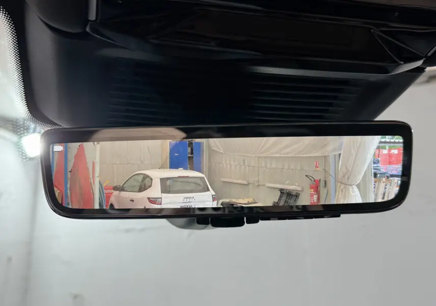 Vue arrière dans le rétroviseur intérieur montrant un Range Rover noir en stationnement intérieur.