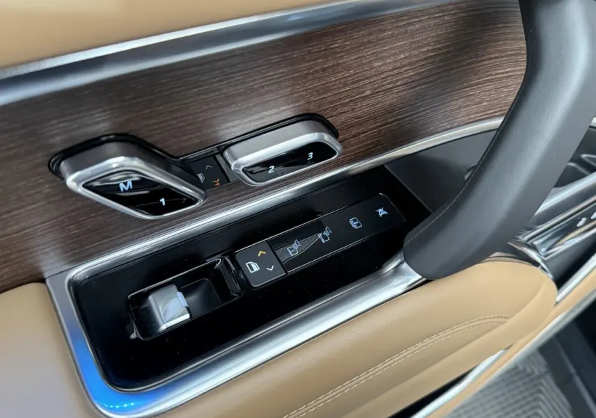 Détail des commandes de réglage de siège et fenêtre sur la portière côté conducteur du Range Rover noir 2024.