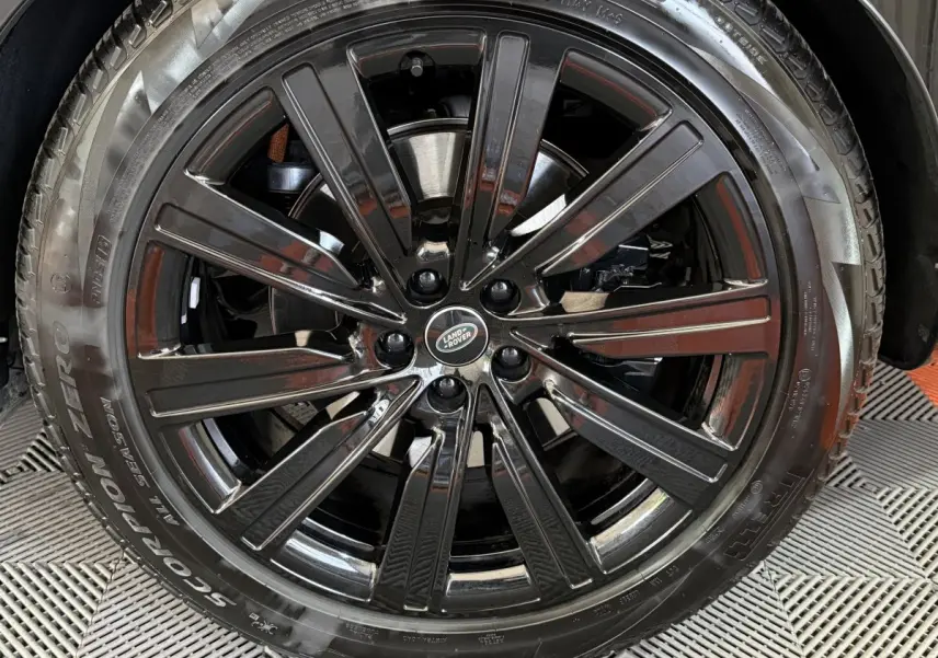 Gros plan sur la jante noire brillante du Range Rover PHEV P550e 2024 avec logo Land Rover au centre.