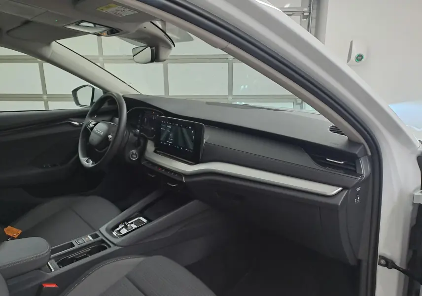 Vue intérieure côté conducteur de la Skoda Octavia Combi blanc Moon 2025, tableau de bord moderne avec écran tactile.