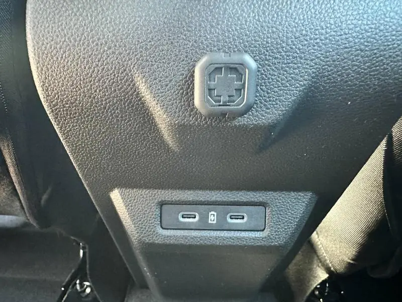 Vue rapprochée des ports USB-C noirs situés à l'arrière de la console centrale du Dacia Bigster blanc.