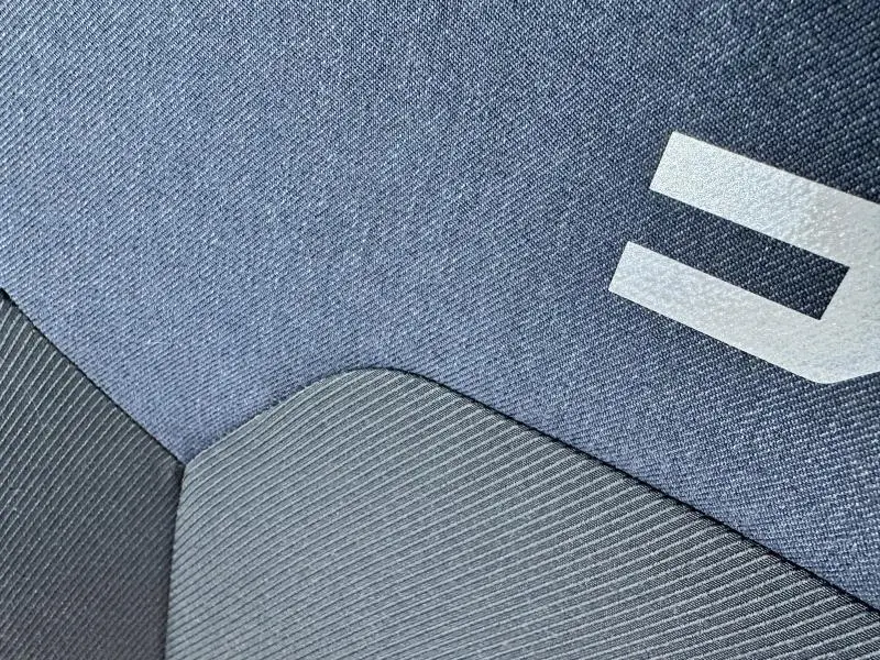 Gros plan sur le tissu bleu et gris du siège avec logo Dacia, intérieur du Dacia Bigster 2025.