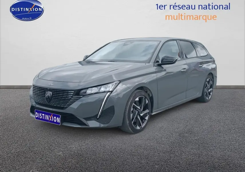 Peugeot 308 SW gris sellenium vue 3/4 avant droit, avec calandre noire et jantes alu distinctives.