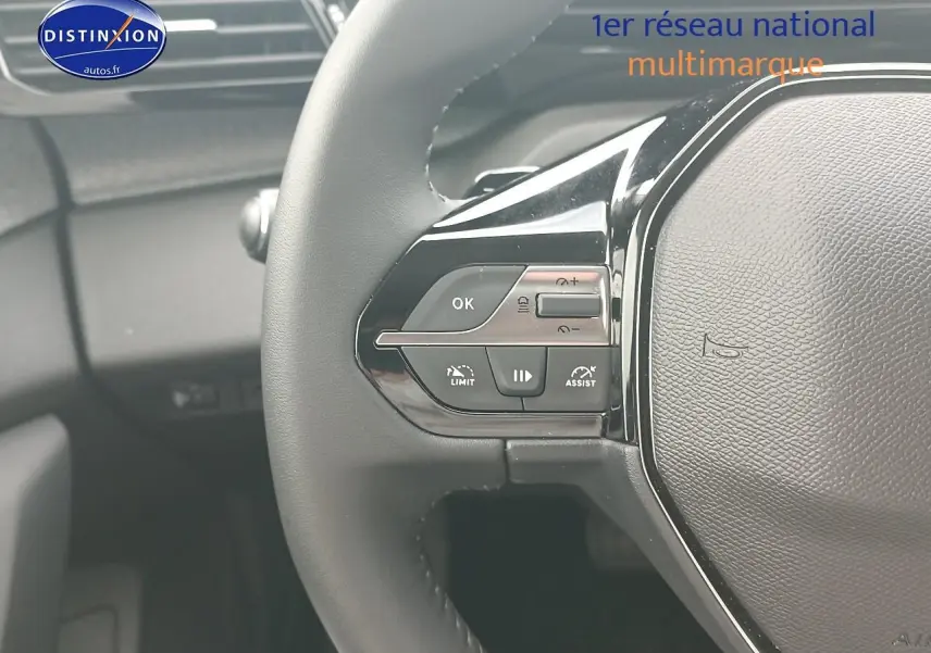 Gros plan sur le volant multifonction noir de la Peugeot 308 SW 1.2 hybrid 145 allure gris sellenium, côté gauche.