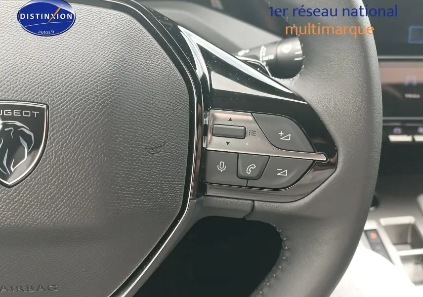 Gros plan sur le volant multifonction noir d'une Peugeot 308 SW 1.2 hybrid 145 allure e-dcs6, intérieur moderne.