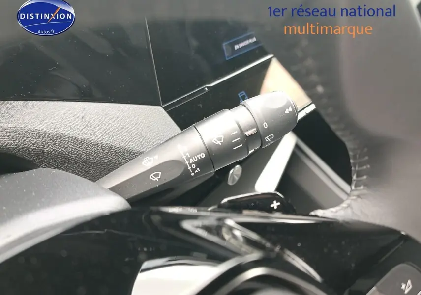 Gros plan sur la commande des essuie-glaces à gauche du volant d’une Peugeot 308 SW gris sélénite, intérieur moderne.
