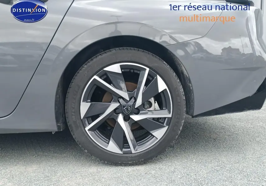 Gros plan sur la roue arrière droite de la Peugeot 308 SW gris sélénite avec jante alu au design moderne.