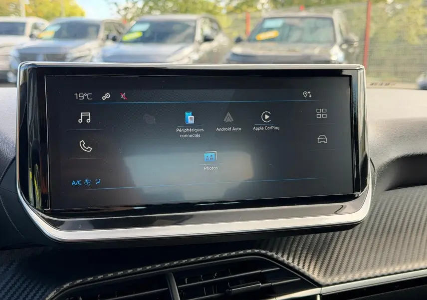 Écran tactile central du tableau de bord de la Peugeot 208 gris Artense, avec interface Android Auto et Apple CarPlay visible.