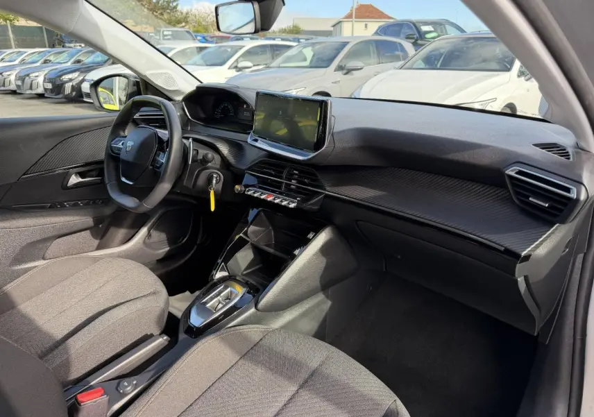 Intérieur avant droit de la Peugeot 208 1.2 Hybrid gris Artense avec tableau de bord moderne et écran tactile central.