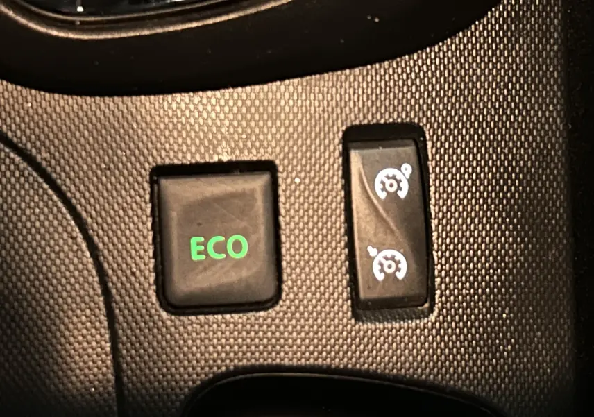 Gros plan sur les boutons ECO et régulateur de vitesse du tableau de bord du Renault Captur orange dCi 90ch energy Intens 2014.