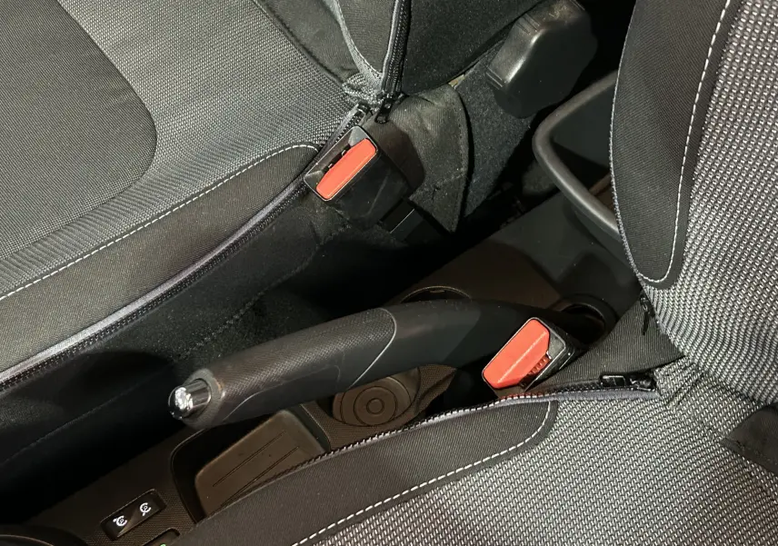 Gros plan intérieur sur le frein à main et les ceintures noires avec surpiqûres blanches du Renault Captur dCi 90ch Intens 2014.