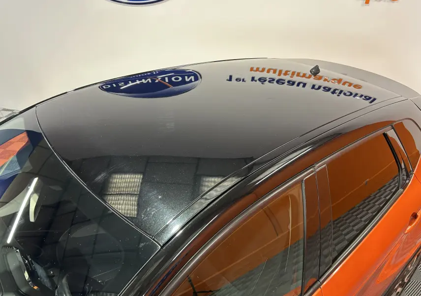 Vue plongeante sur le toit noir brillant et la partie supérieure orange vif côté droit du Renault Captur dCi 90ch energy Intens 2014.