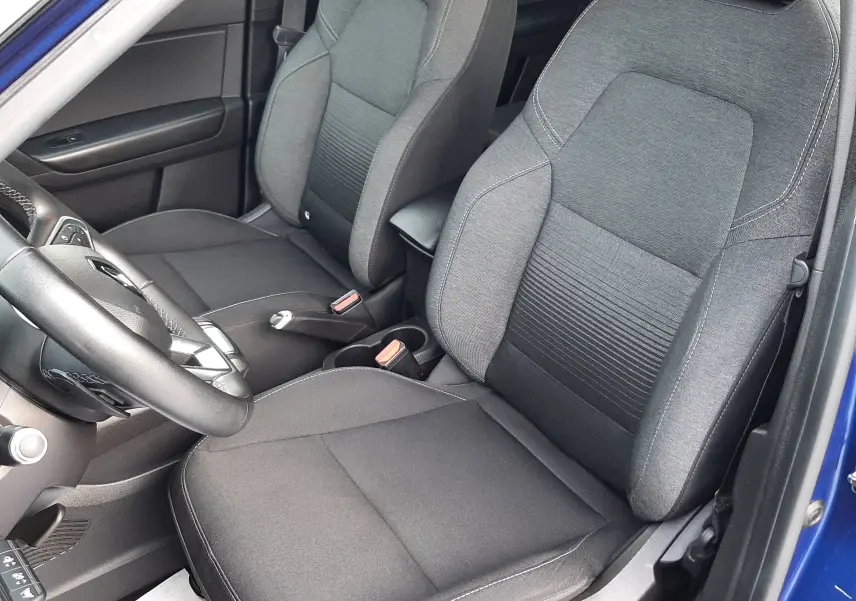 Intérieur du Renault Captur 2020 vu côté conducteur, sièges tissu noir avec contours gris, portière bleu iron ouverte.