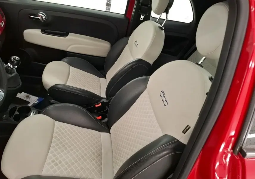 Vue intérieure côté droit montrant les sièges bi-ton beige et noir avec logo 500 sur une FIAT 500 rouge Dolcevita 2021.
