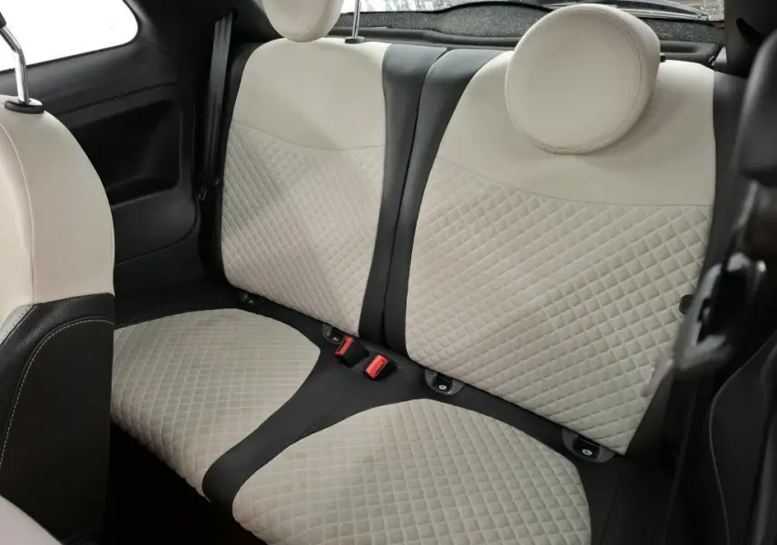 Vue intérieure sur les sièges arrière beige matelassés avec appuie-têtes ronds de la Fiat 500 Dolcevita rouge de 2021.