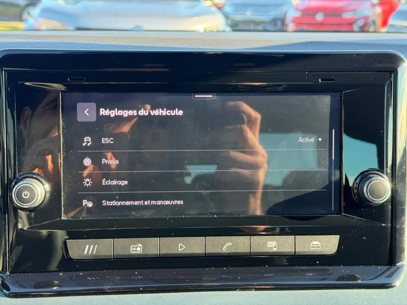 Écran tactile central du SEAT Arona 2025 affichant les réglages du véhicule, avec reflets et commandes en noir brillant.