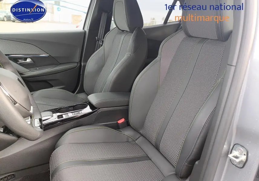 Vue intérieure côté conducteur de la Peugeot 2008 1.2 hybrid 145 GT e-DCS6 avec sièges tissu et cuir gris anthracite.