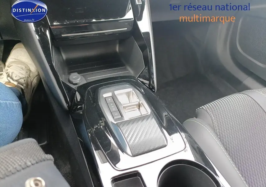 Vue rapprochée de la console centrale noire brillante avec levier de vitesse automatique et siège tissu gris Peugeot 2008 1.2 hybrid 145 GT.