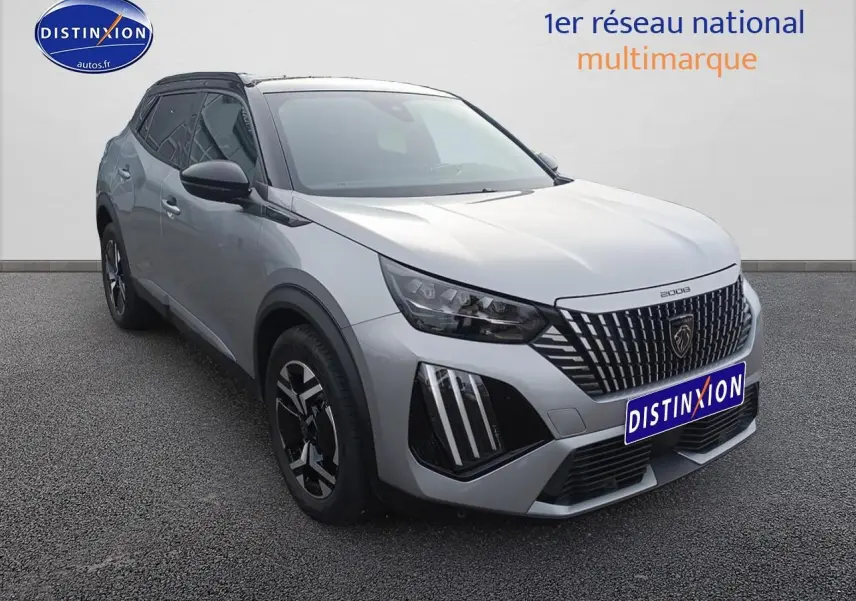 Peugeot 2008 hybride 2025 gris Artense en 3/4 avant, avec calandre distinctive et jantes alu noires.