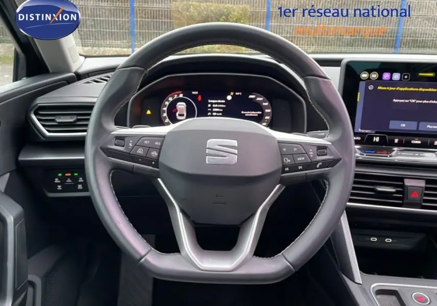 Vue intérieure centrée sur le volant de la SEAT LEON 2025 avec tableau de bord numérique et écran tactile.